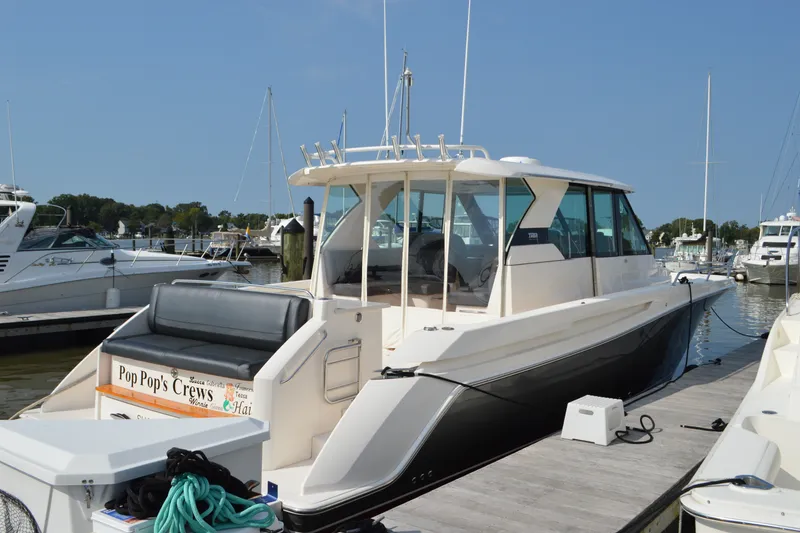 Slide: The Image of 2016 Tiara Yachts Q44 docked at marina, featuring sleek design and spacious deck. - 19