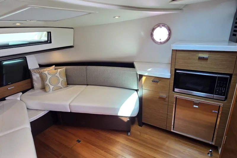 Slide: The Image of 2016 Tiara Yachts Q44 interior with modern seating, kitchenette, and wood flooring. - 63