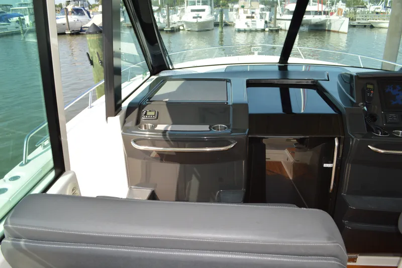 Slide: The Image of 2016 Tiara Yachts Q44 helm with modern controls and marina view. - 58
