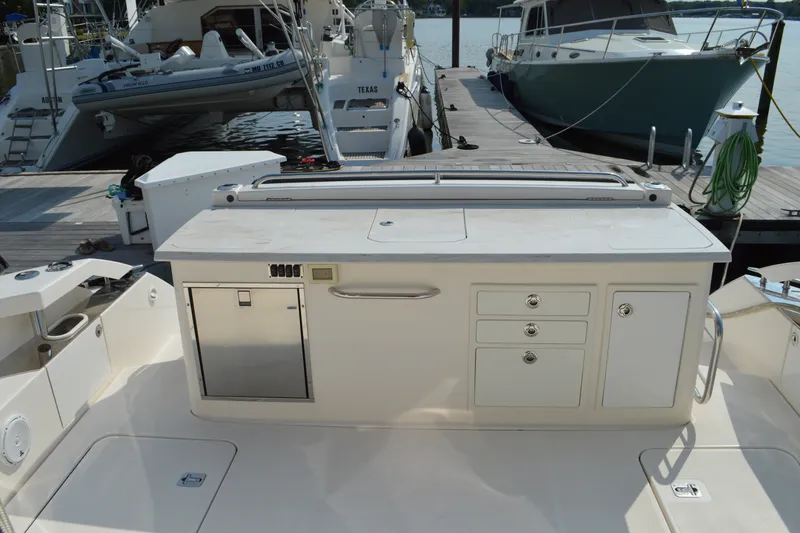 Slide: The Image of 2016 Tiara Yachts Q44 yacht deck with storage and docked boats in background. - 21