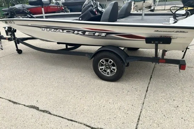 The Image of 2024 Tracker Pro Team 175 TXW Tournament Edition boat on trailer, parked on concrete. - 0