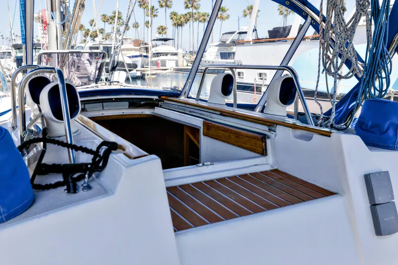 Slide: The Image of Jeanneau Sun Magic 44 sailboat cockpit, 1990 model, with wooden deck and marina background. - 21