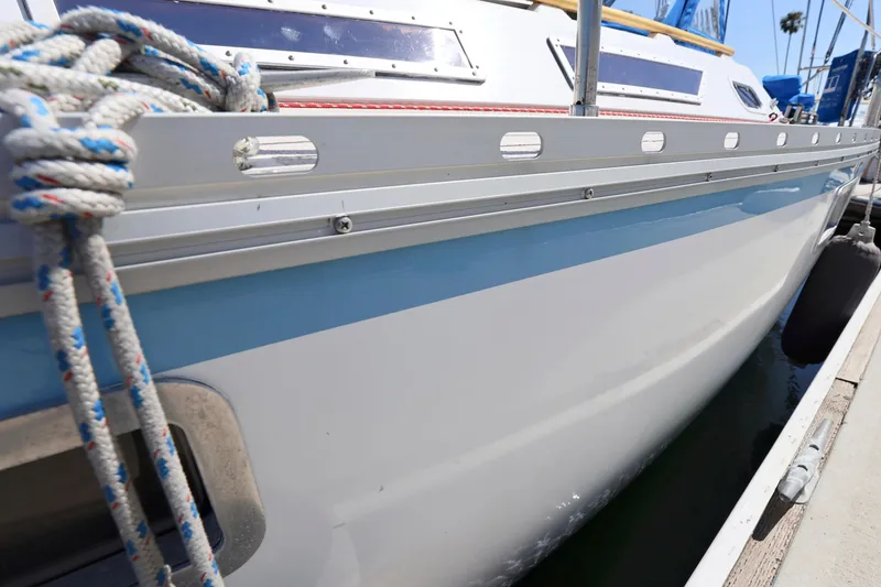 Slide: The Image of 1990 Jeanneau Sun Magic 44 sailboat docked, showcasing sleek hull and nautical ropes. - 30