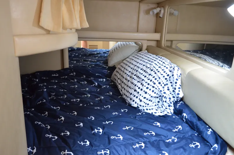 Slide: The Image of Cozy cabin interior of 1998 Sea Ray 290 Sundancer with nautical-themed bedding. - 55