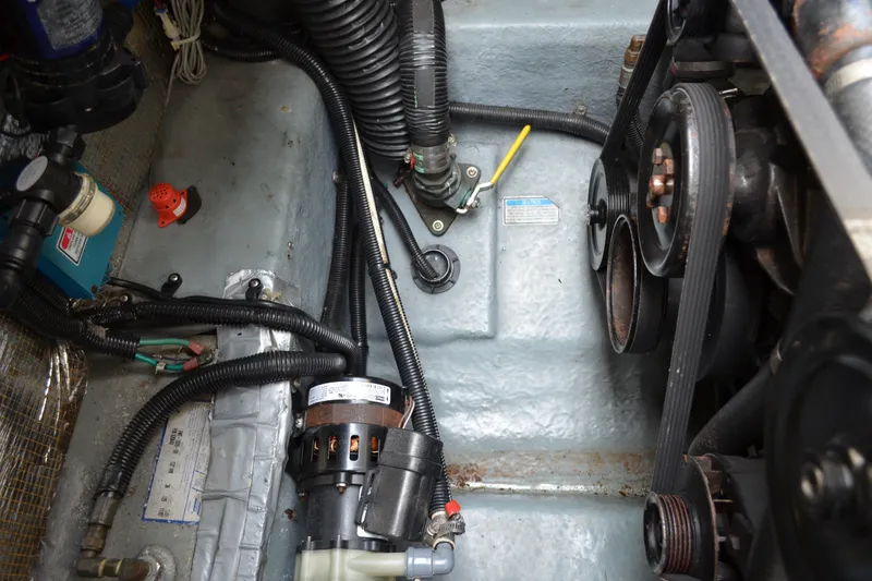 Slide: The Image of Engine compartment of a 1998 Sea Ray 290 Sundancer boat, showing belts and hoses. - 64