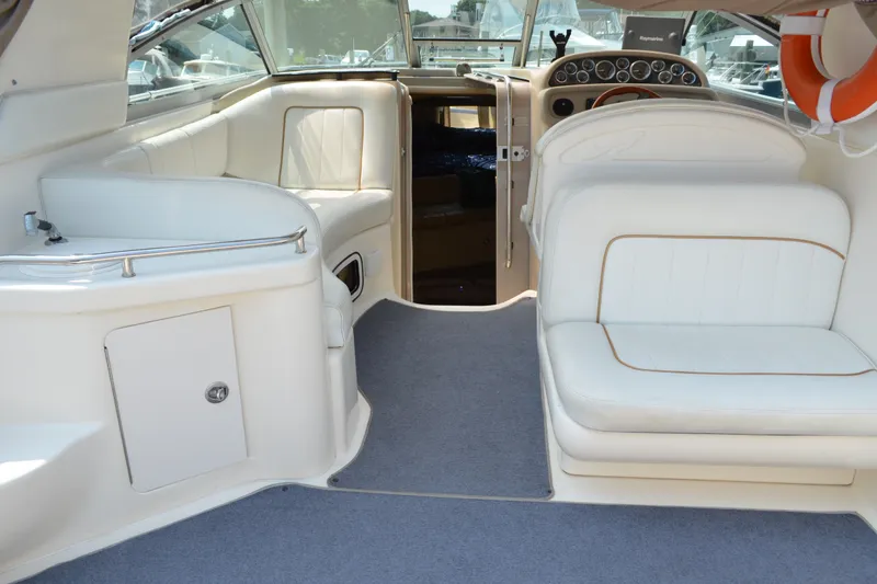 Slide: The Image of 1998 Sea Ray 290 Sundancer interior with white seating and dashboard view. - 18