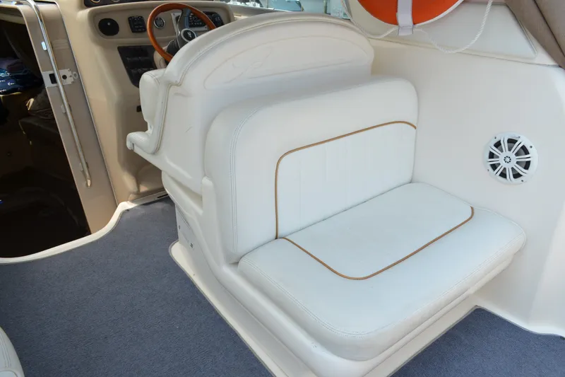 Slide: The Image of 1998 Sea Ray 290 Sundancer interior with white seating and steering wheel. - 25