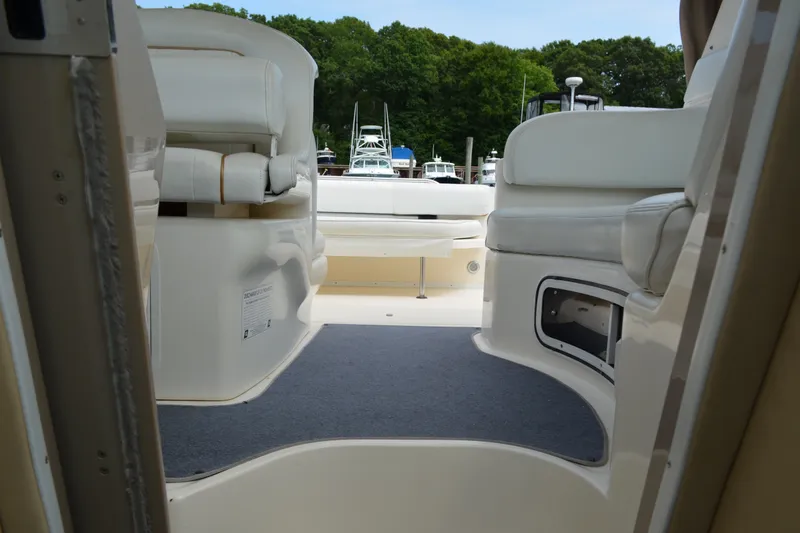 Slide: The Image of Interior view of a 1998 Sea Ray 290 Sundancer boat with white seating and carpeted floor. - 53