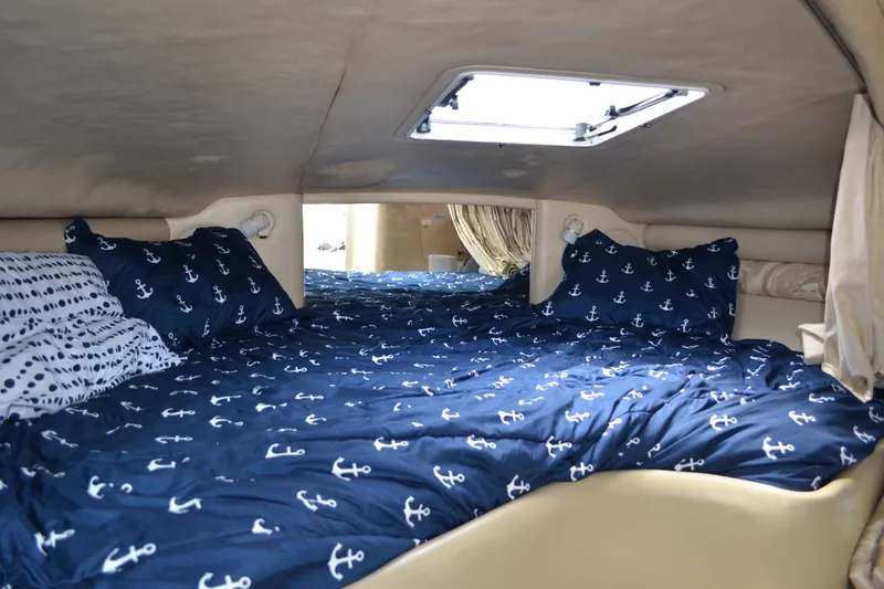 Slide: The Image of Cozy cabin interior of 1998 Sea Ray 290 Sundancer with nautical-themed bedding. - 43