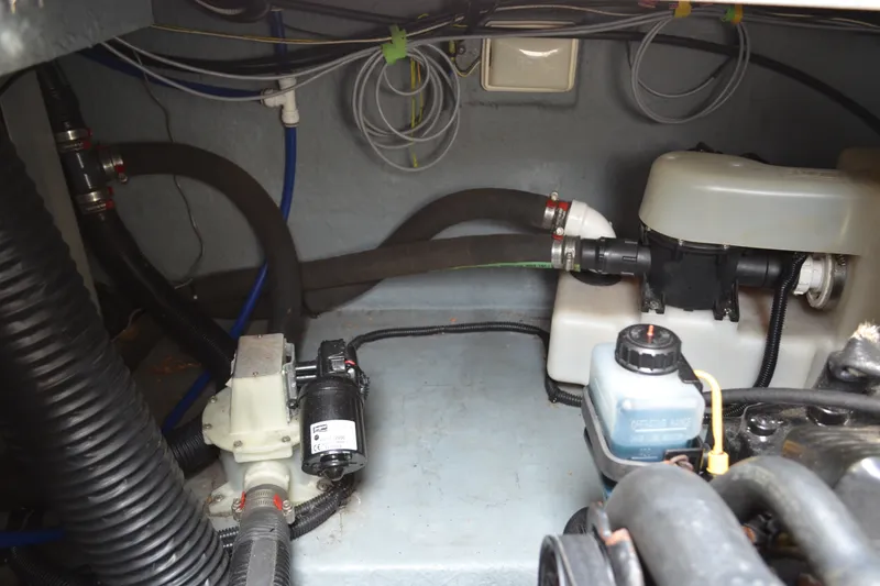 Slide: The Image of Engine compartment of a 1998 Sea Ray 290 Sundancer boat, showing hoses and components. - 65