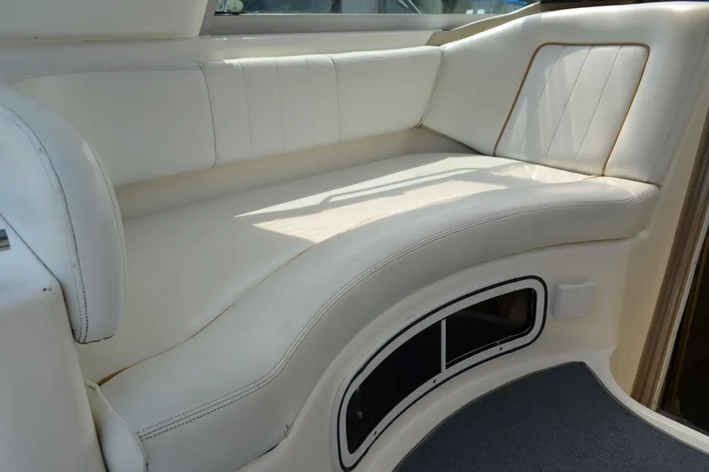 Slide: The Image of 1998 Sea Ray 290 Sundancer interior with white leather seating and curved design. - 29