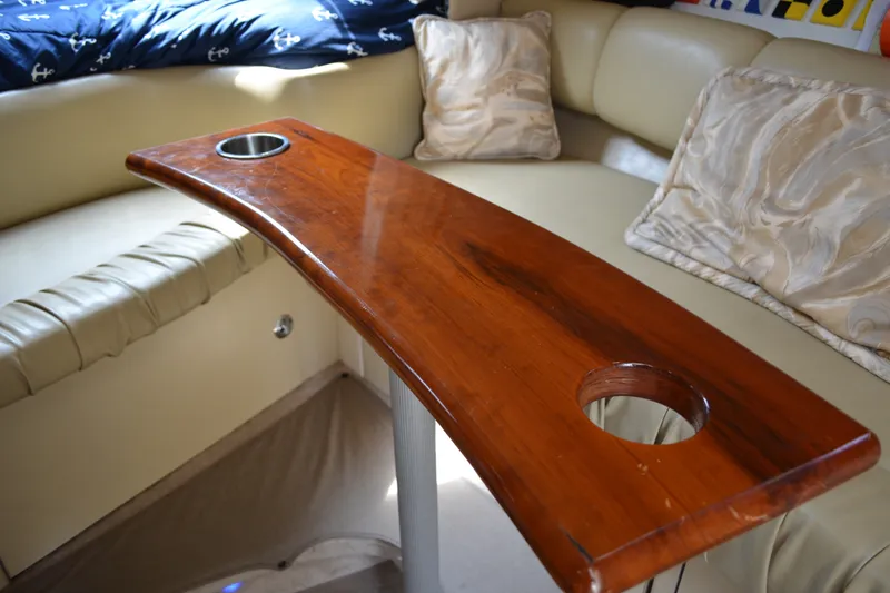 Slide: The Image of Interior of 1998 Sea Ray 290 Sundancer with wooden table and beige seating. - 46