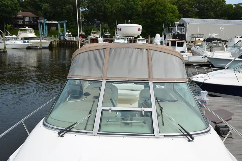 Slide: The Image of 1998 Sea Ray 290 Sundancer docked at a marina with surrounding boats. - 14