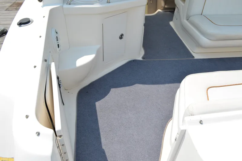 Slide: The Image of 1998 Sea Ray 290 Sundancer boat interior with carpeted flooring and seating area. - 19