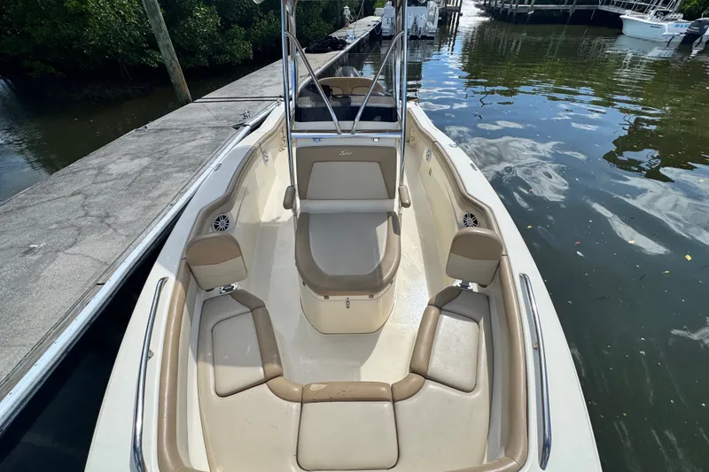 Slide: The Image of 2022 Scout 215 XSF boat docked, featuring spacious seating and sleek design. - 21