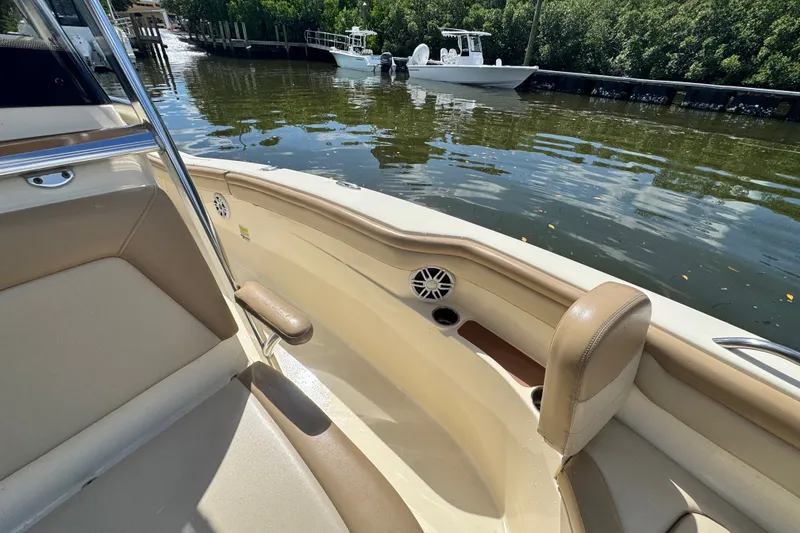 Slide: The Image of 2022 Scout 215 XSF boat interior with beige seating and water view. - 23