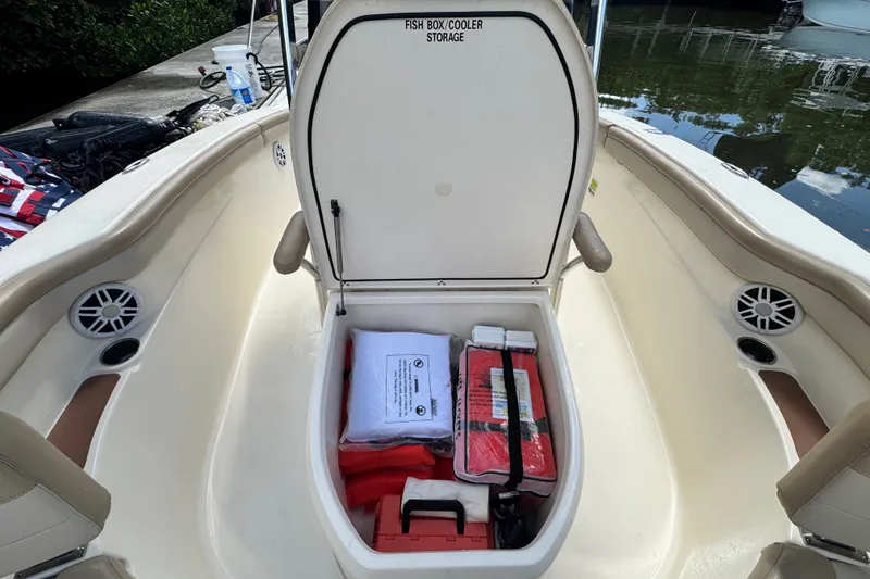 Slide: The Image of 2022 Scout 215 XSF boat with open fish box cooler storage, containing safety equipment. - 19