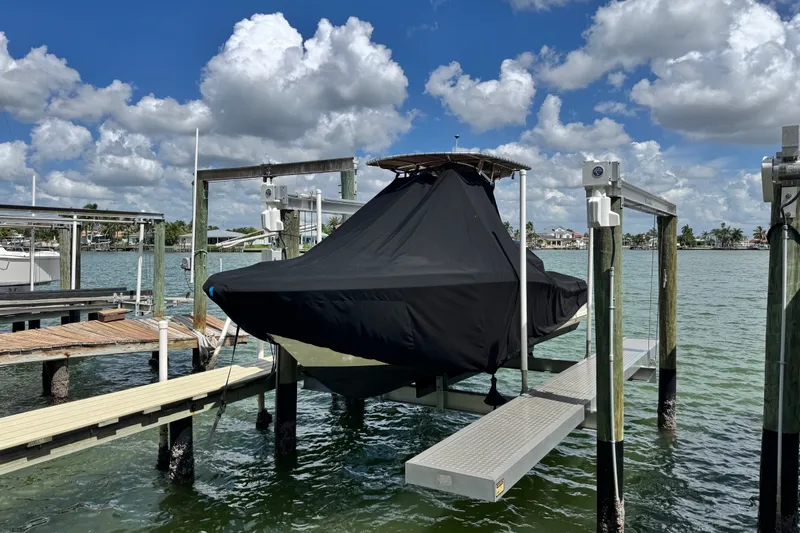 Slide: The Image of 2022 Scout 215 XSF boat covered on a lift at a marina. - 51