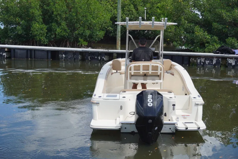 Slide: The Image of 2022 Scout 215 XSF boat with Mercury 200 engine on calm water near dock. - 14