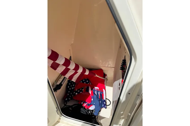 Slide: The Image of Interior storage of 2022 Scout 215 XSF boat with American flag and life jackets. - 45