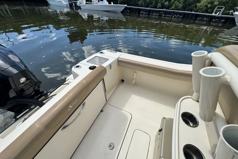 Slide: The Image of 2022 Scout 215 XSF boat interior with seating and rod holders by the water. - 37