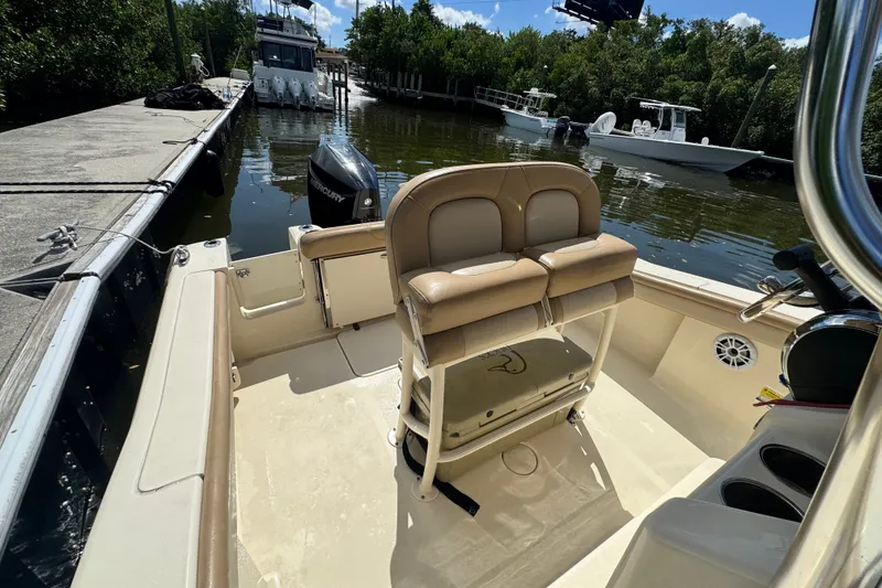Slide: The Image of 2022 Scout 215 XSF boat interior with seating and Mercury engine at dock. - 28