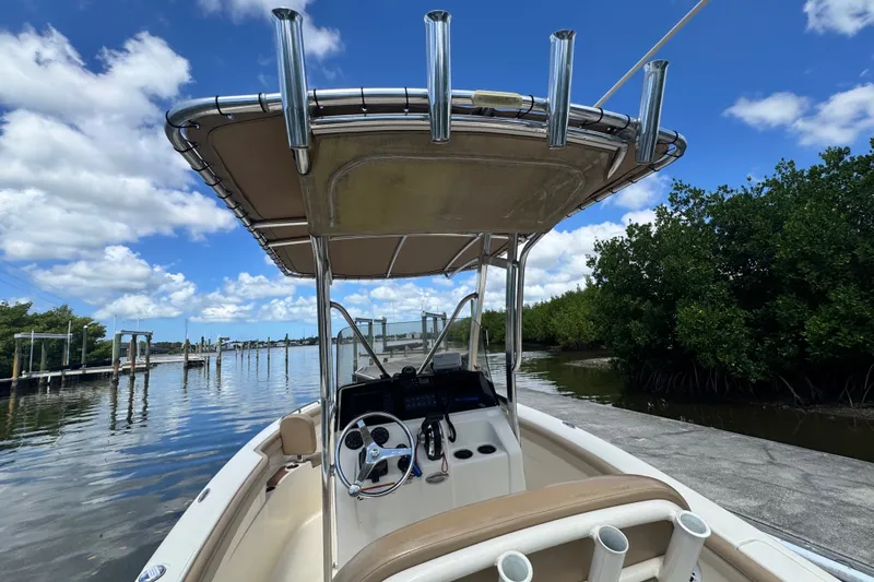 Slide: The Image of 2022 Scout 215 XSF boat docked by lush mangroves under a clear blue sky. - 43