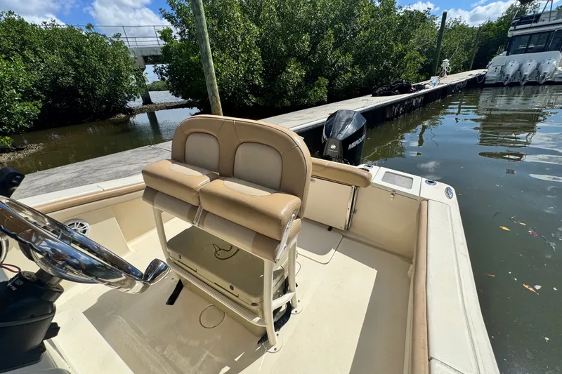 Slide: The Image of 2022 Scout 215 XSF boat docked by lush greenery and calm waters. - 25