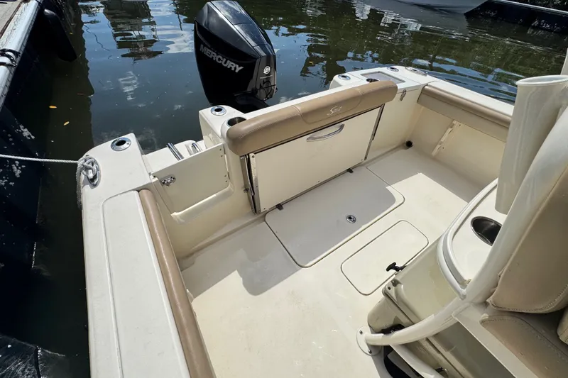 Slide: The Image of 2022 Scout 215 XSF boat interior with Mercury outboard motor, docked on calm water. - 36