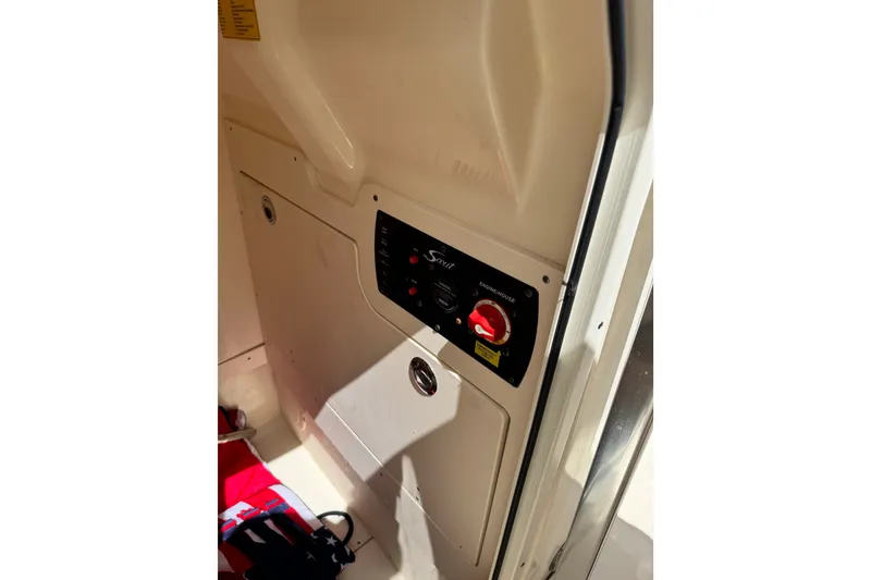 Slide: The Image of Control panel inside 2022 Scout 215 XSF boat, featuring switches and storage compartment. - 46
