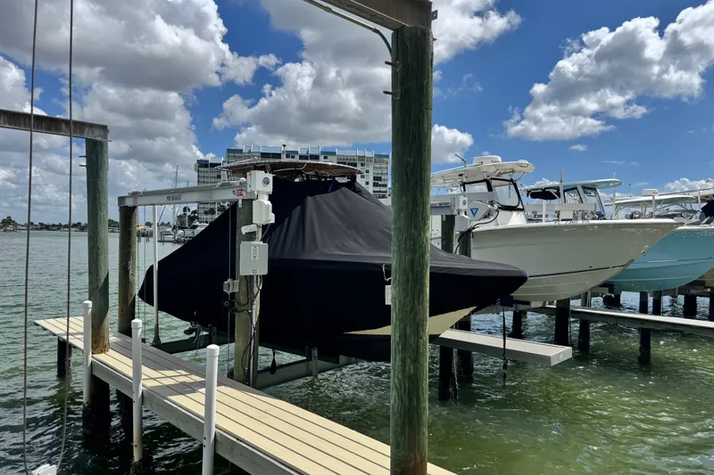 Slide: The Image of Covered 2022 Scout 215 XSF boat docked on a sunny day with clouds. - 52