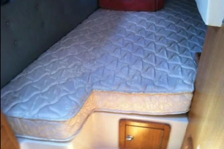 Slide: The Image of 2005 Catalina 36 MkII cabin with a comfortable mattress and wooden storage compartment. - 7