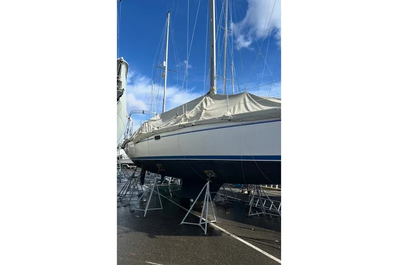 Slide: The Image of 2005 Catalina 36 MkII sailboat on stands, covered, under a clear blue sky. - 32