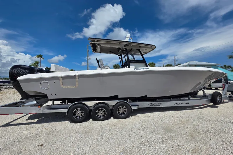 The Image of 2019 Fountain 38 Center Console boat on trailer under clear blue sky. - 0