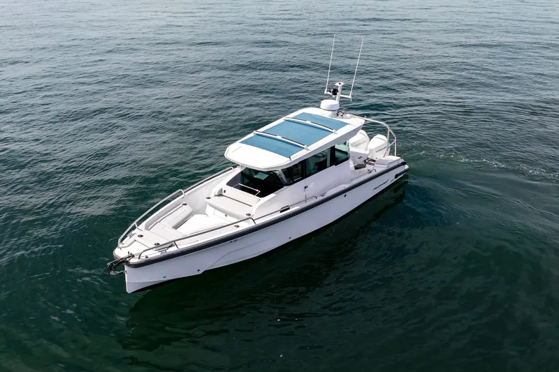 Slide: The Image of 2027 Axopar 29 XC Cross Cabin boat on calm water. - 7