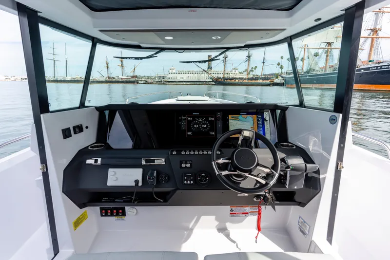 Slide: The Image of Interior view of 2027 Axopar 29 XC Cross Cabin boat cockpit with steering wheel and navigation screens. - 17