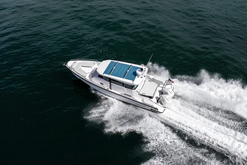 Slide: The Image of 2027 Axopar 29 XC Cross Cabin cruising on open water, aerial view. - 5
