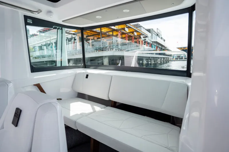 Slide: The Image of Interior of 2027 Axopar 29 XC Cross Cabin with white seating and large windows. - 18