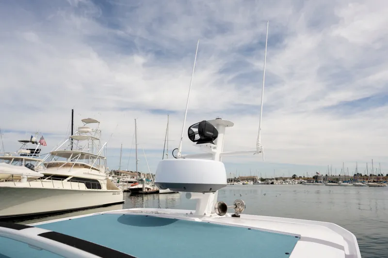 Slide: The Image of 2027 Axopar 29 XC Cross Cabin boat docked in a marina under a cloudy sky. - 11