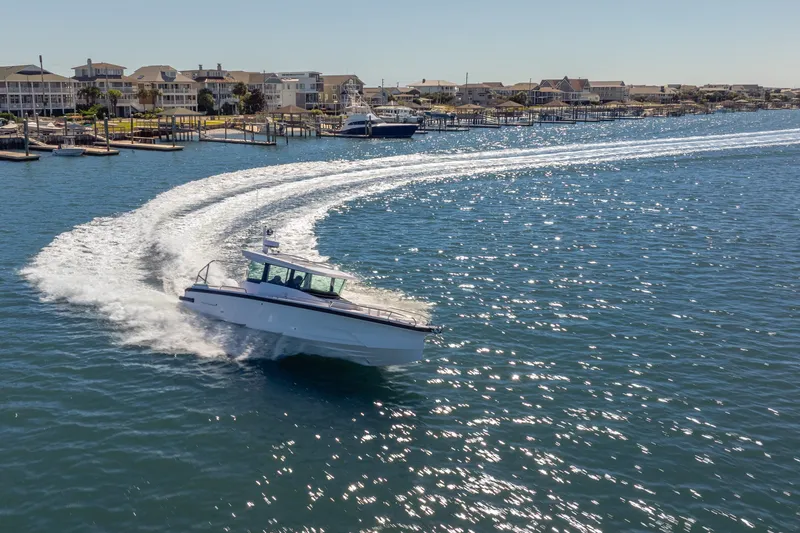 Slide: The Image of 2027 Axopar 29 XC Cross Cabin cruising in sunny coastal waters. - 2