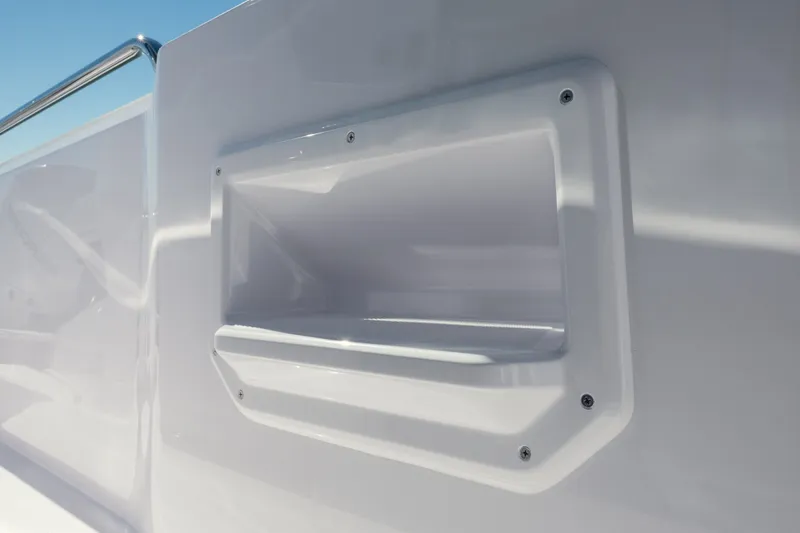 Slide: The Image of 2027 Axopar 29 XC Cross Cabin, white exterior detail with built-in storage compartment. - 23