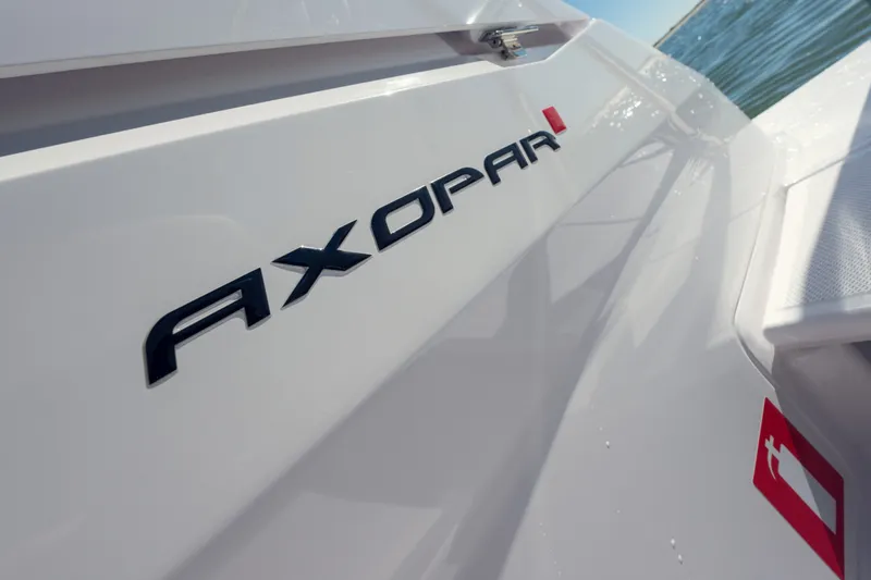 Slide: The Image of 2027 Axopar 29 XC Cross Cabin boat logo on sleek white exterior. - 21