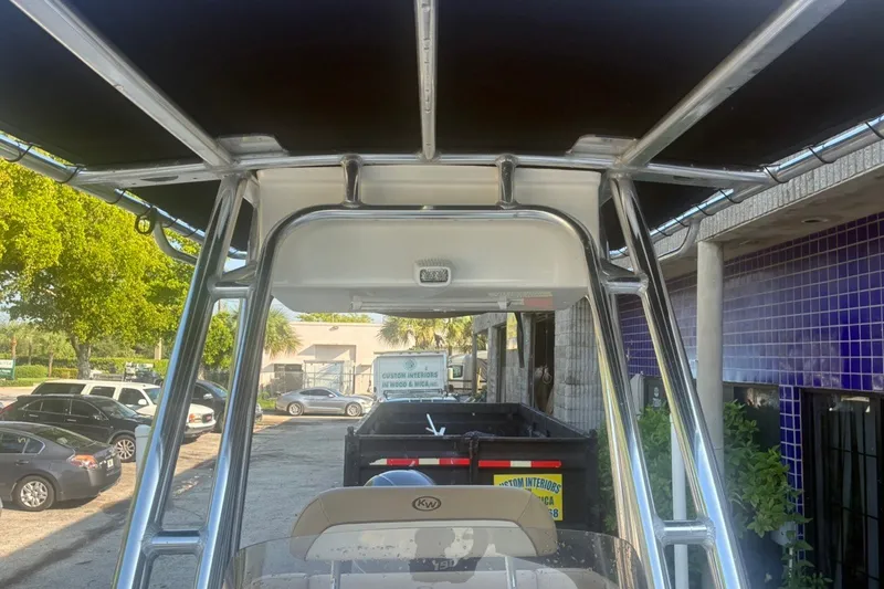 Slide: The Image of 2020 Key West 203 FS boat with T-top frame, parked outdoors. - 40
