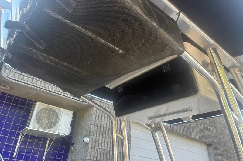 Slide: The Image of 2020 Key West 203 FS boat with storage compartment and canopy, near a building with air conditioning unit. - 28