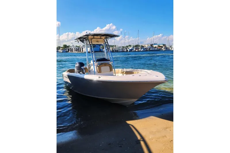 The Image of 2020 Key West 203 FS boat docked on a sunny shoreline with marina background. - 1