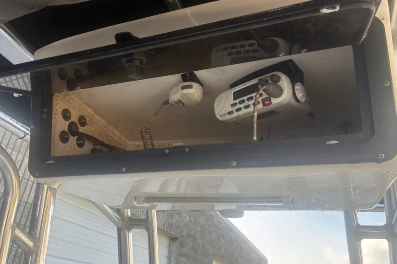 Slide: The Image of Storage compartment with radio equipment on a 2020 Key West 203 FS boat. - 54