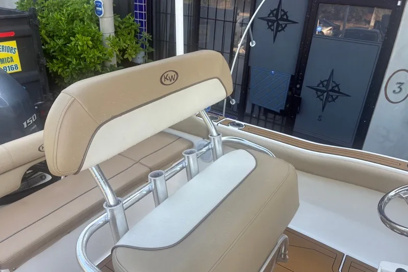 Slide: The Image of 2020 Key West 203 FS boat interior with beige seating and rod holders. - 23