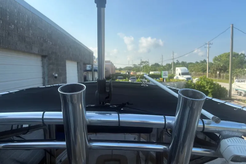 Slide: The Image of 2020 Key West 203 FS boat with stainless steel rod holders, parked near industrial buildings. - 34