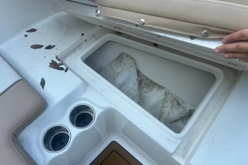 Slide: The Image of Open storage compartment on a 2020 Key West 203 FS boat with cup holders and leaves. - 43