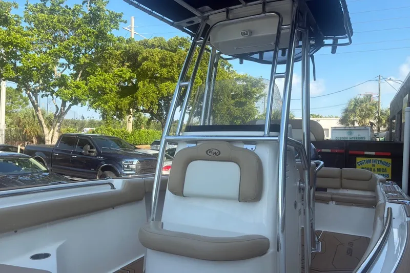 Slide: The Image of 2020 Key West 203 FS boat interior with seating and console, parked outdoors. - 17